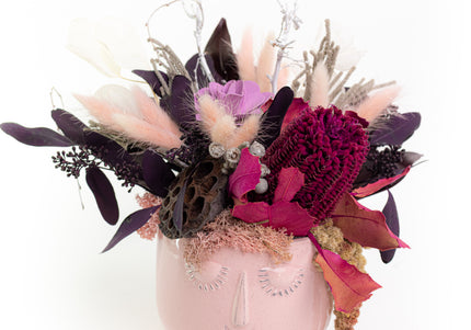 Aranjament Floral „Pink Reverie” în Vas Sculptural Roz – Decor Handmade cu Banksia Purpurie, Flori Criogenate și Accente Catifelate