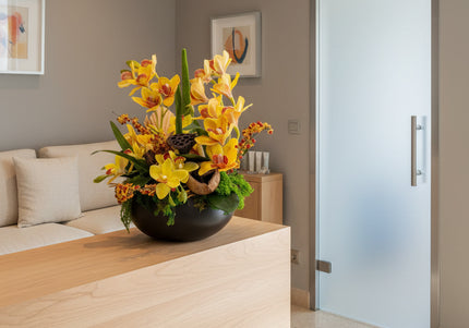 Aranjament Floral „Solar Orchid” în Vas Ceramic Negru – Decor de Lux cu Orhidee Galbene, Ilex și Accente Botanice Exotice